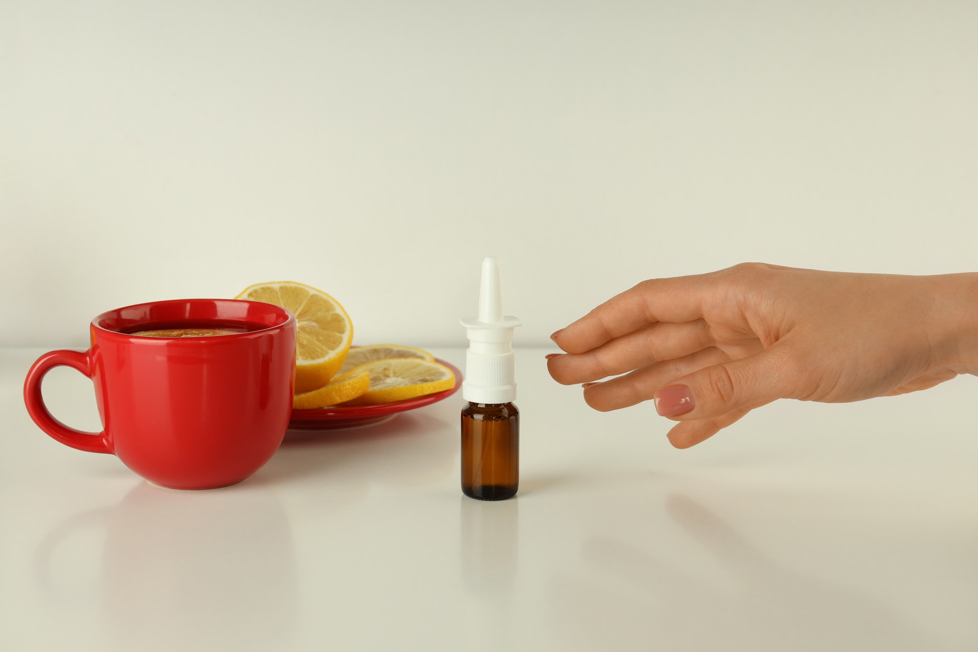 Female hand takes bottle of nasal spray, close up