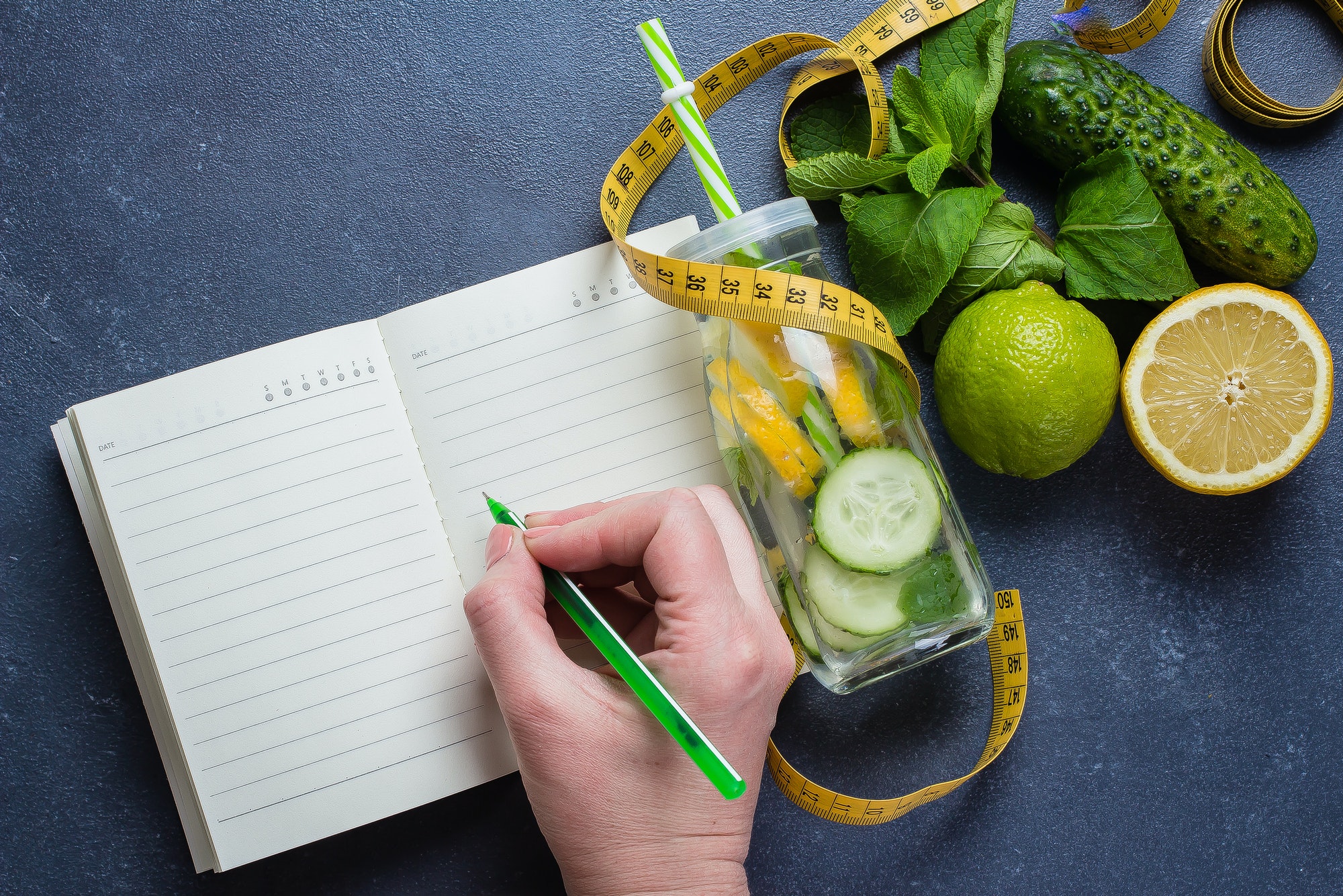 Woman writing nutrition plan diet menu and fitness workout routine.